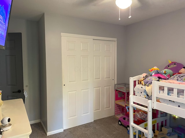 bedroom featuring dark carpet, a closet, and ceiling fan