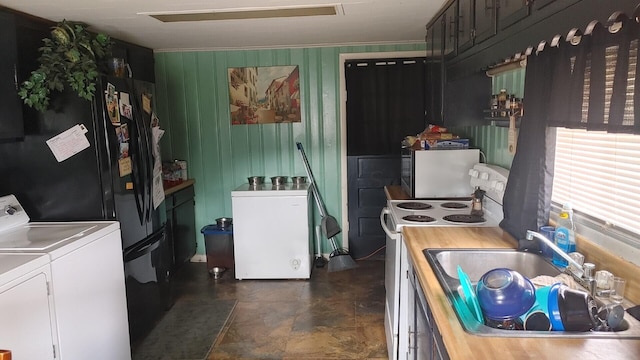 kitchen featuring sink, refrigerator, washer and dryer, and stainless steel range with electric stovetop