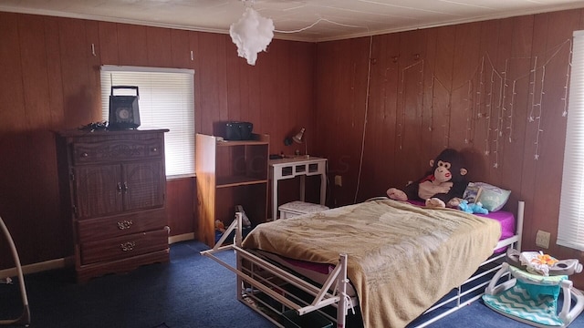 bedroom featuring dark colored carpet and wooden walls