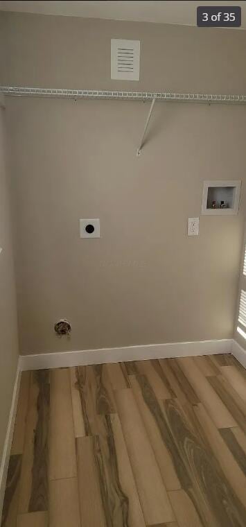 clothes washing area with hookup for an electric dryer, hookup for a washing machine, and hardwood / wood-style flooring