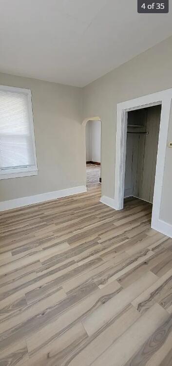 unfurnished bedroom featuring light hardwood / wood-style flooring and a closet