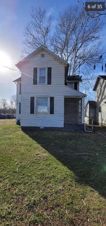 back of house featuring a lawn