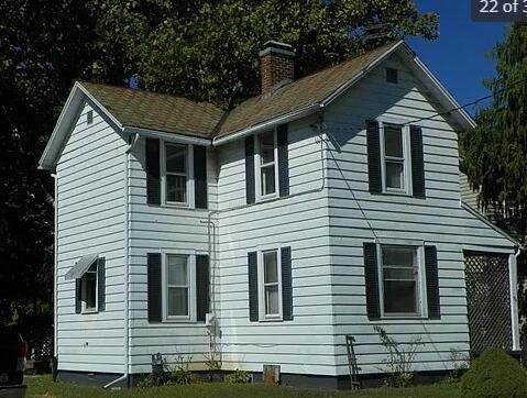 view of side of home with a yard