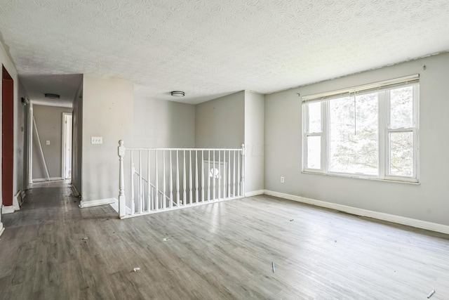 unfurnished room featuring hardwood / wood-style floors and a textured ceiling