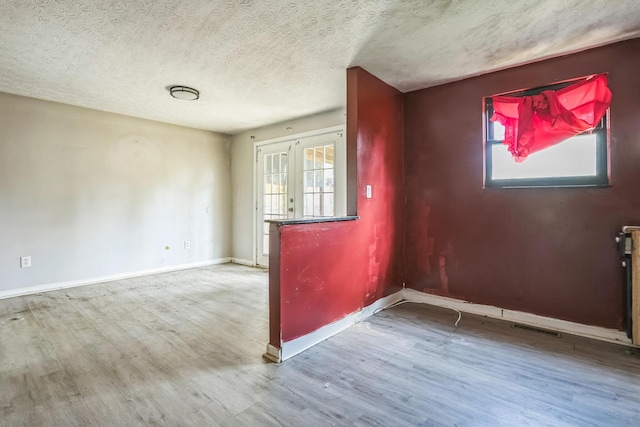 spare room with hardwood / wood-style flooring, a wealth of natural light, and french doors