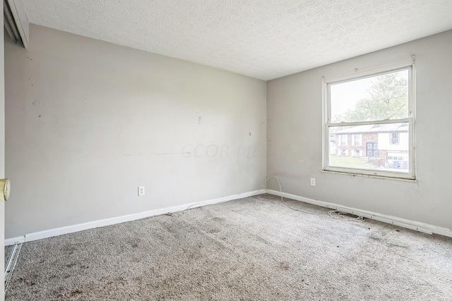 carpeted spare room featuring a textured ceiling