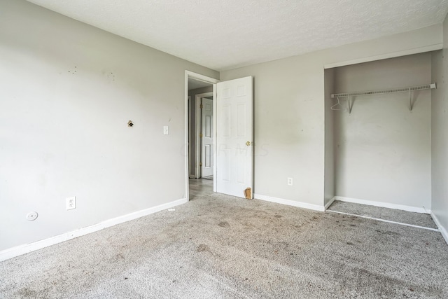 unfurnished bedroom featuring carpet, a textured ceiling, and a closet