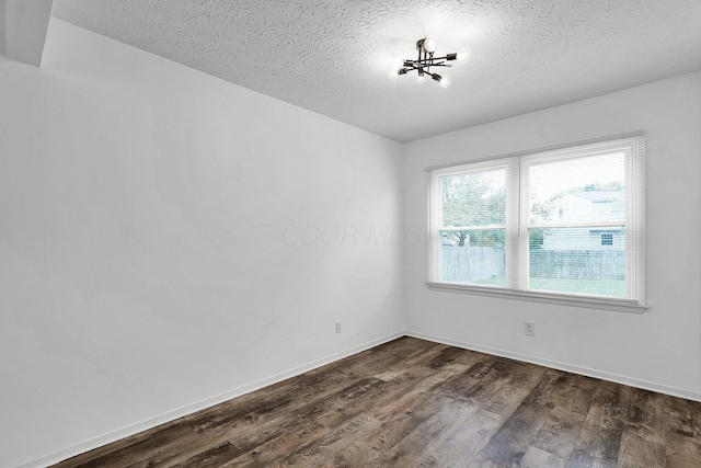 empty room featuring dark hardwood / wood-style flooring and a textured ceiling