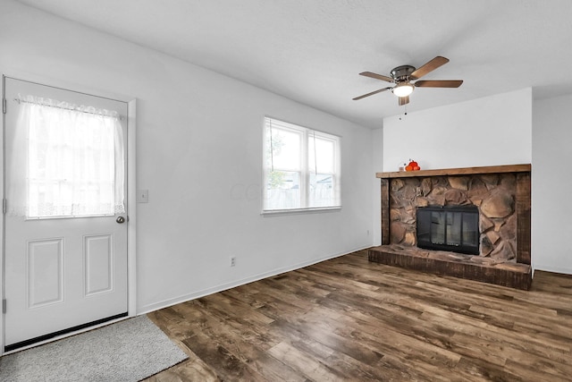 unfurnished living room with a fireplace, ceiling fan, and dark hardwood / wood-style flooring