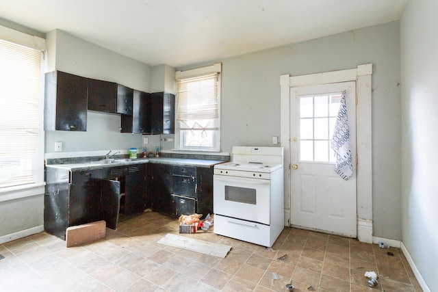 kitchen featuring electric stove, dark brown cabinetry, and sink