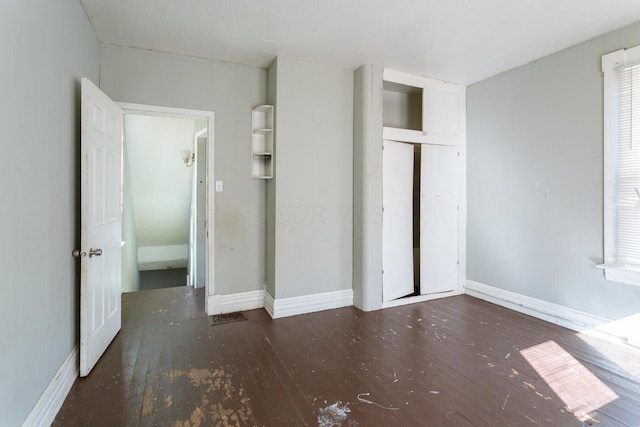 unfurnished bedroom with dark wood-type flooring