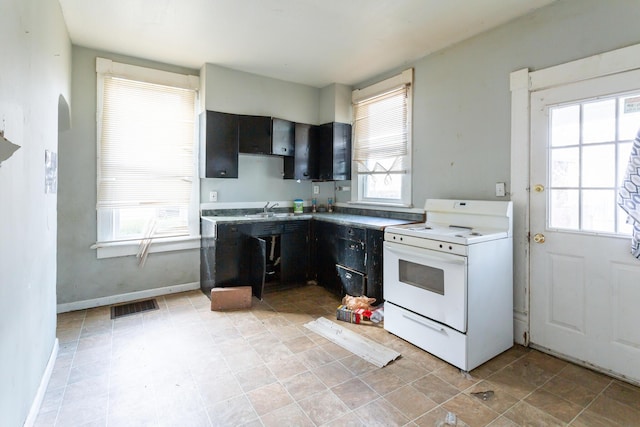 kitchen with sink, white electric stove, and a wealth of natural light