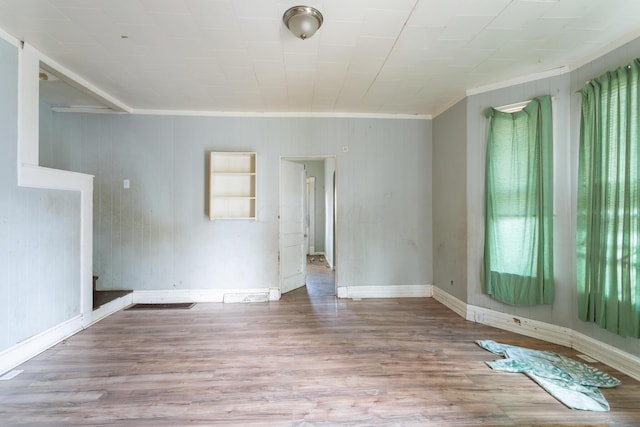 unfurnished room with plenty of natural light, wood-type flooring, and ornamental molding