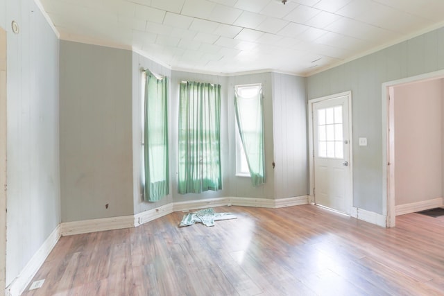 empty room with light hardwood / wood-style flooring and crown molding