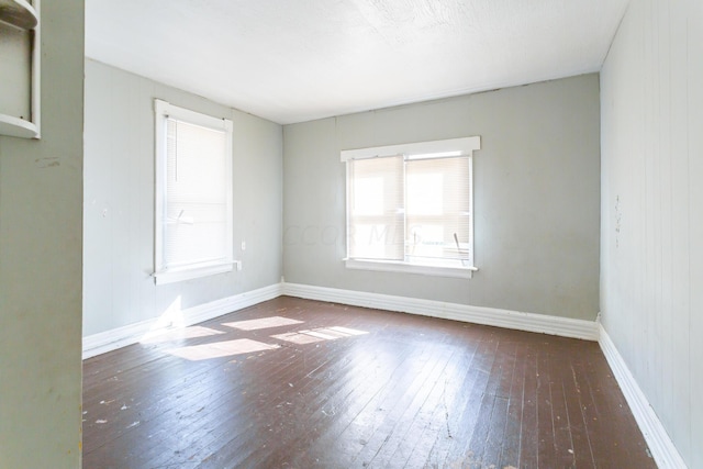 unfurnished room with dark wood-type flooring