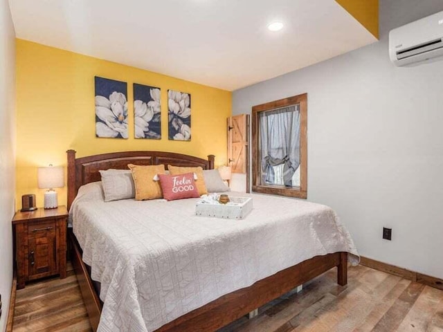 bedroom featuring wood-type flooring and a wall unit AC