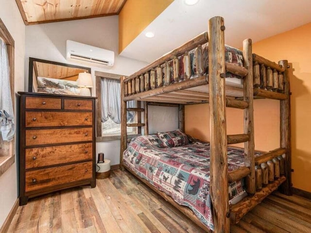 bedroom featuring hardwood / wood-style flooring, wooden ceiling, a wall unit AC, and vaulted ceiling