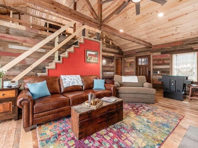 living room with wood walls, vaulted ceiling with beams, light hardwood / wood-style floors, and wood ceiling