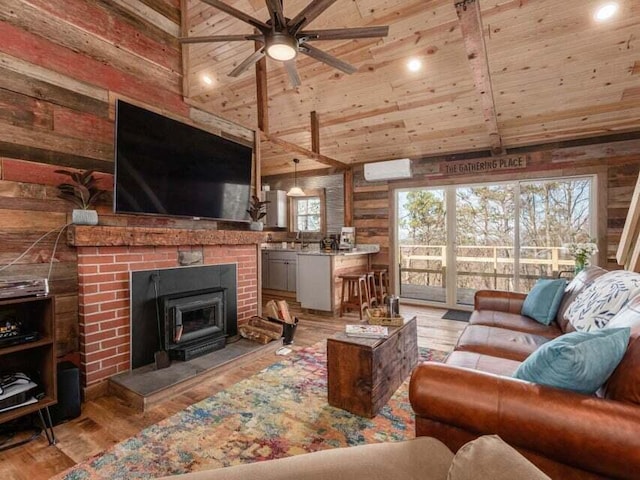 living room with wood walls, high vaulted ceiling, light hardwood / wood-style flooring, ceiling fan, and wood ceiling