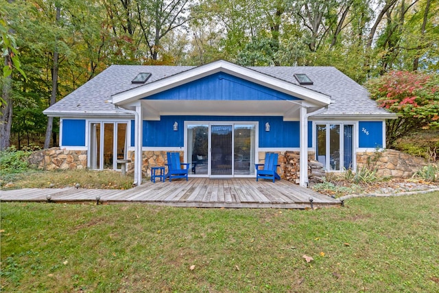 back of property featuring a lawn and a deck