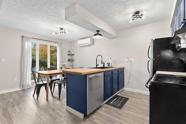 kitchen featuring butcher block counters, sink, stainless steel dishwasher, a wall unit AC, and light wood-type flooring