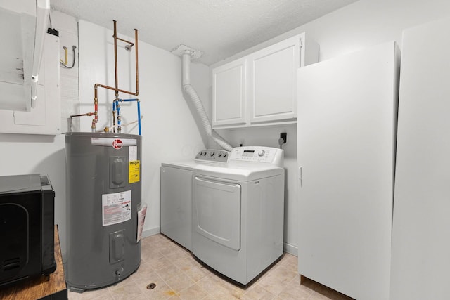 laundry area featuring electric water heater, washer and dryer, cabinets, and a textured ceiling