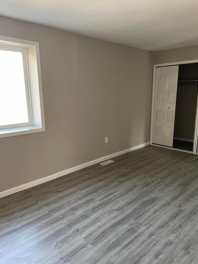 unfurnished bedroom with wood-type flooring and a closet