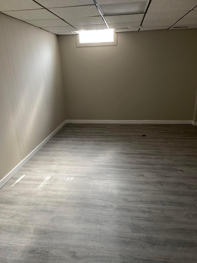 basement with a drop ceiling and wood-type flooring