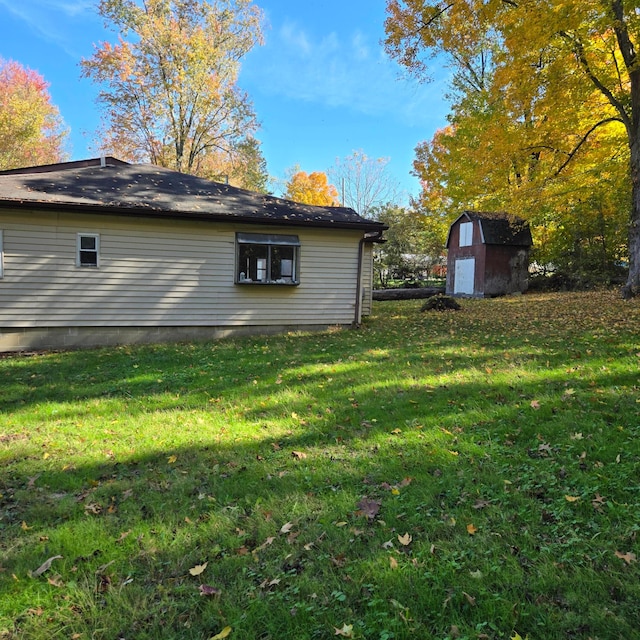 view of side of property featuring a storage shed, a lawn, and an outbuilding