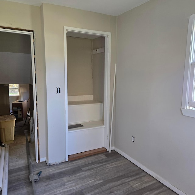 unfurnished bedroom with wood finished floors and baseboards