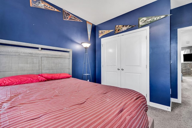 carpeted bedroom with a closet and vaulted ceiling