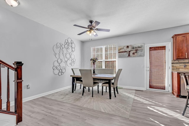 dining space featuring a textured ceiling, light hardwood / wood-style flooring, and ceiling fan