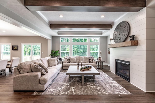 living room featuring a textured ceiling, beamed ceiling, and dark hardwood / wood-style floors