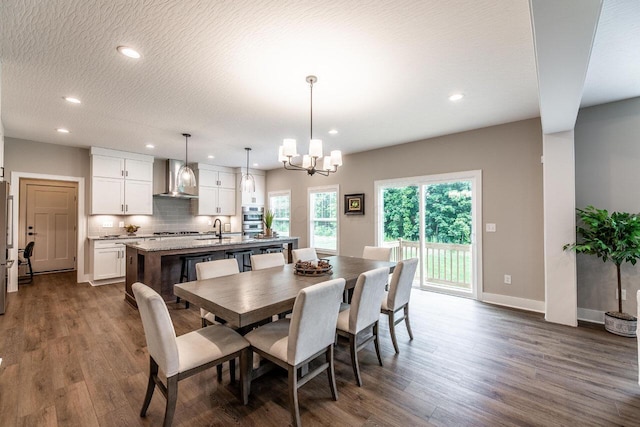 dining area with a textured ceiling, sink, a chandelier, and dark hardwood / wood-style floors