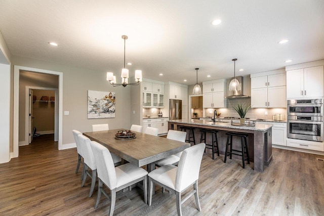 dining area featuring light hardwood / wood-style flooring, a chandelier, and sink