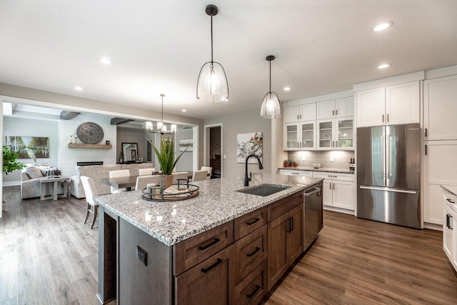 kitchen with a kitchen island with sink, sink, dark hardwood / wood-style floors, and appliances with stainless steel finishes