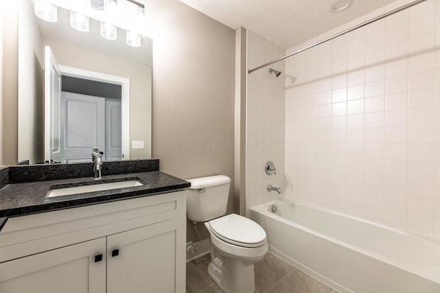 full bathroom featuring tiled shower / bath combo, tile patterned floors, a textured ceiling, toilet, and vanity