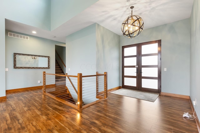 foyer with french doors, a notable chandelier, and hardwood / wood-style floors