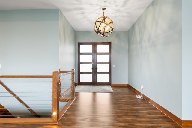 foyer entrance featuring french doors, dark wood-type flooring, and a notable chandelier