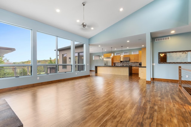 unfurnished living room featuring hardwood / wood-style flooring and high vaulted ceiling