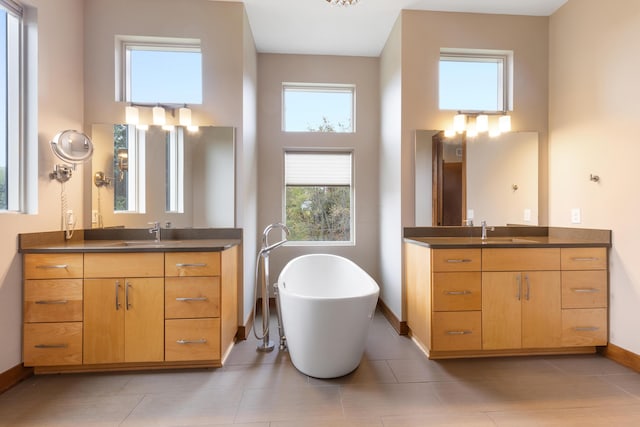 17311 Gambier Rd, Mount Vernon, OH 43050 - full bath featuring two vanities, a towering ceiling, a soaking tub, and healthy amount of natural light
