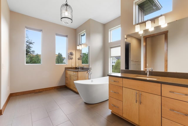 17311 Gambier Rd, Mount Vernon, OH 43050 - bathroom featuring healthy amount of natural light, two vanities, a freestanding tub, and a chandelier