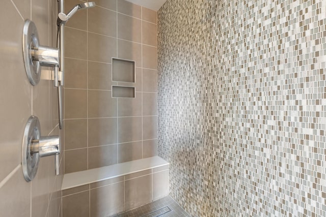 bathroom with tiled shower and tile patterned floors