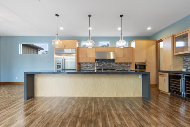 kitchen with stainless steel appliances, dark wood-type flooring, exhaust hood, light brown cabinets, and wine cooler