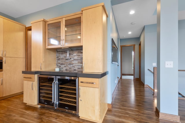 bar with light brown cabinets, backsplash, dark wood-type flooring, oven, and wine cooler