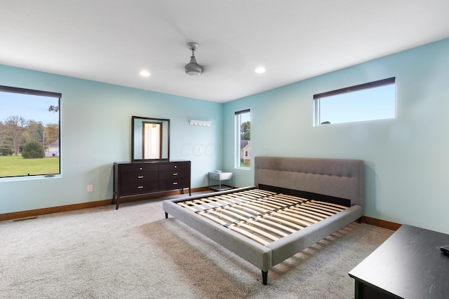 carpeted bedroom with ceiling fan and multiple windows