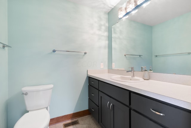 bathroom with tile patterned flooring, vanity, and toilet