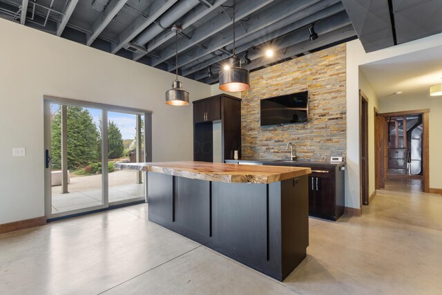 17311 Gambier Rd, Mount Vernon, OH 43050 - kitchen with finished concrete floors, butcher block countertops, a kitchen island, dark brown cabinets, and a towering ceiling