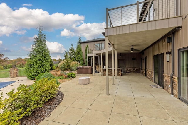 view of patio / terrace featuring ceiling fan, a balcony, and a hot tub