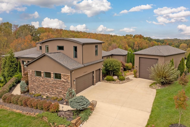 17311 Gambier Rd, Mount Vernon, OH 43050 - view of front of house with stone siding, driveway, an attached garage, and roof with shingles